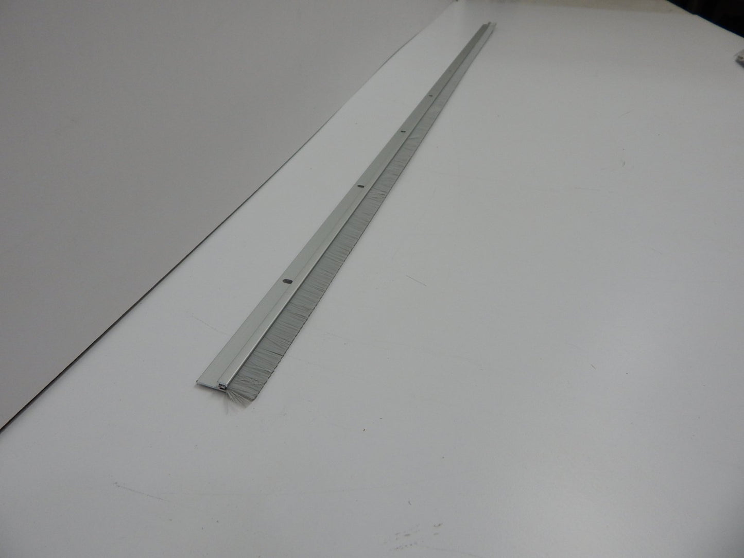 Pemko Brush Door Bottom Sweep, Clear Anodized Aluminum with 0.625" Gray Nylon Brush insert, 0.25" Width, 1.375" H x 48" L - 18061CNB48