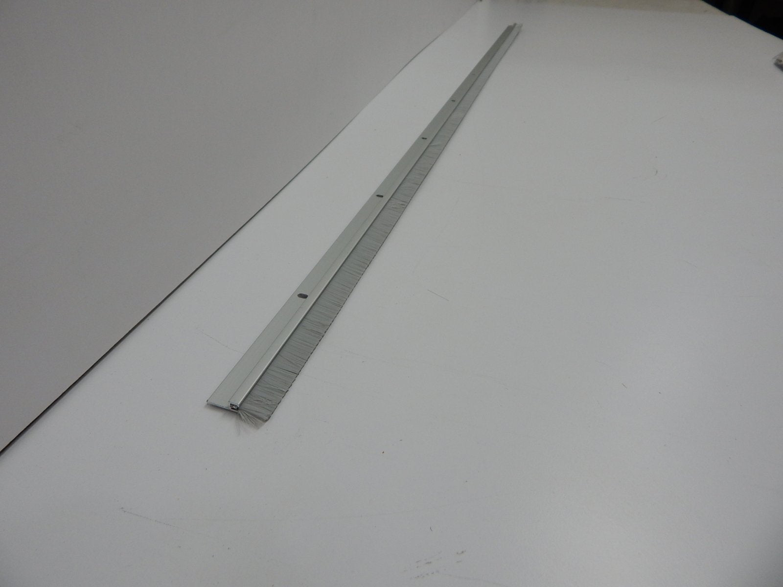Pemko Brush Door Bottom Sweep, Clear Anodized Aluminum with 0.625" Gray Nylon Brush insert, 0.25" Width, 1.375" H x 48" L - 18061CNB48