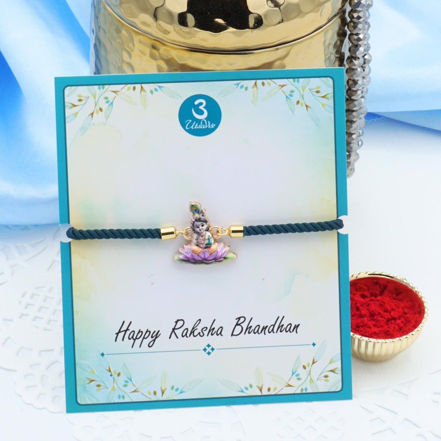 UtsaWe Rakhi Gift Box | Devine Rakhi Hamper with Elegant Krishna Rakhi Bracelet, Roli, Chawal, Mini Thali Set, A Chocolate, And A Greeting Card